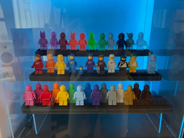 Multi-colored LEGO minifigures in a 3-tier display case