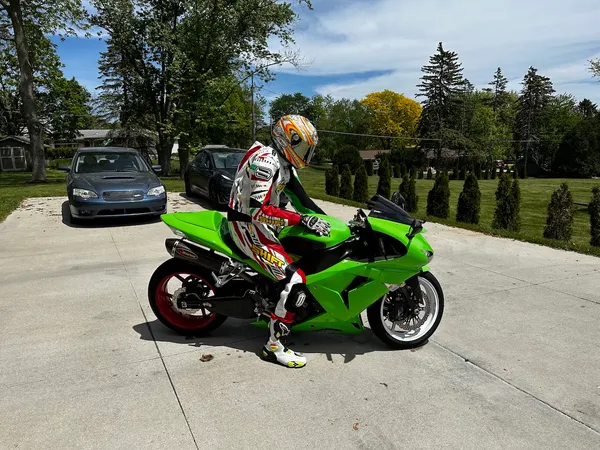 Me in a full leather racing suit sitting on my green sportbike